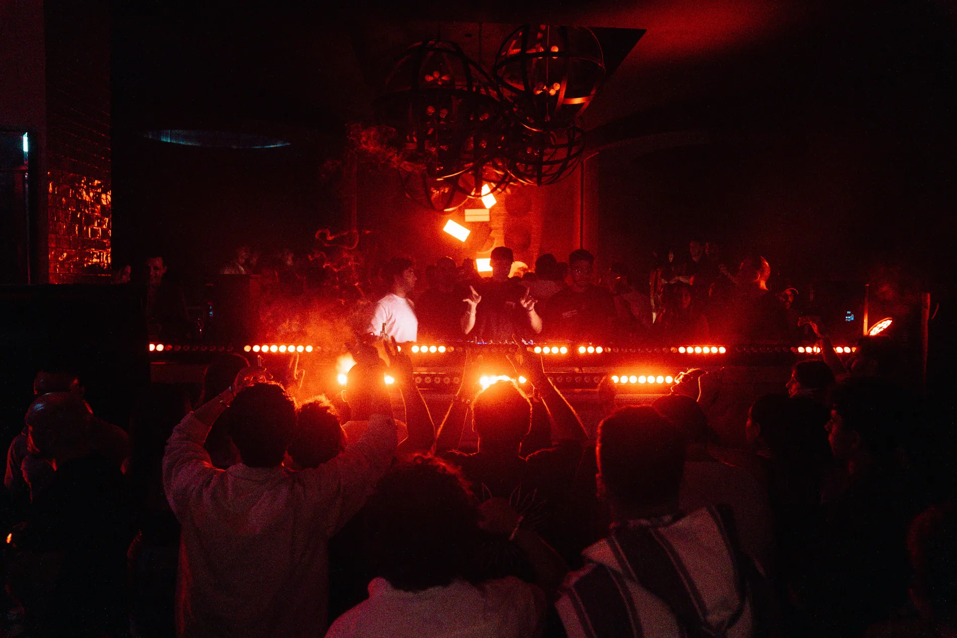 Live electronic music performance under red stage lights